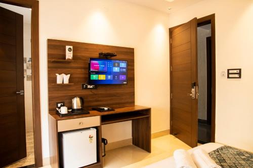 a room with a desk with a tv on a wall at Hotel Dream Inn in Rishīkesh
