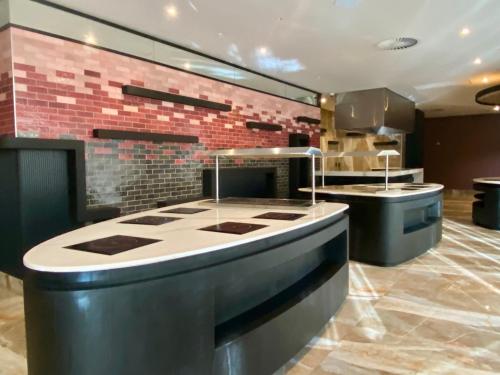 a kitchen with a counter and a brick wall at Coastlands Skye Hotel, Ridgeside, Umhlanga in Durban