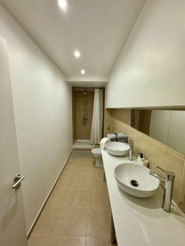 La salle de bains est pourvue de 2 lavabos et de 2 toilettes. dans l'établissement Expérience cinéma immersif dans appartement rénové près de Montmartre, à Paris