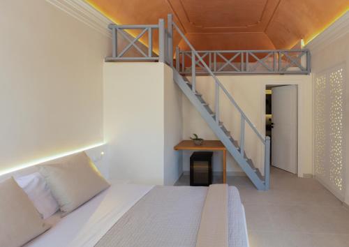 a bedroom with a bed and a staircase at Kykladonisia Traditional Settlement in Fira