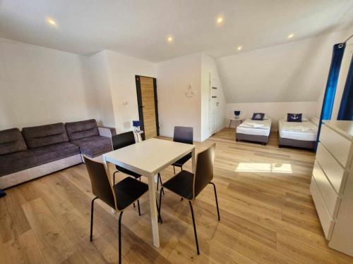 a living room with a table and chairs and a couch at Pokoje u Emilii ul. Warszawska in Mikołajki