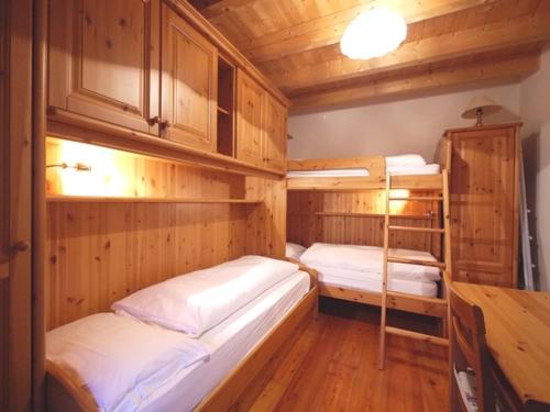 two bunk beds in a room with wooden walls at Appartamenti Home Service in Arabba