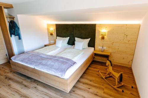 ein Schlafzimmer mit einem großen Bett und Holzboden in der Unterkunft Meisterbauerhof in Ainring