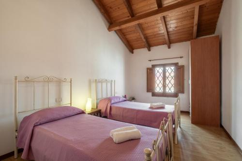 una camera con due letti e una finestra di Villa Vintage con giardino e palestra a Riola Sardo