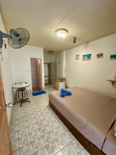 a bedroom with a bed and a table and a fan at Plaza Huahin in Hua Hin