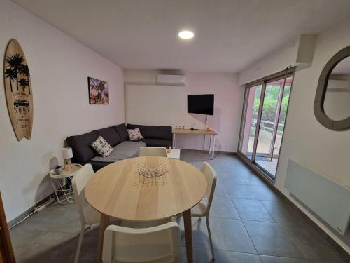 a living room with a table and a couch at Rez-de-jardin sous pins et plage in Saint-Mandrier-sur-Mer
