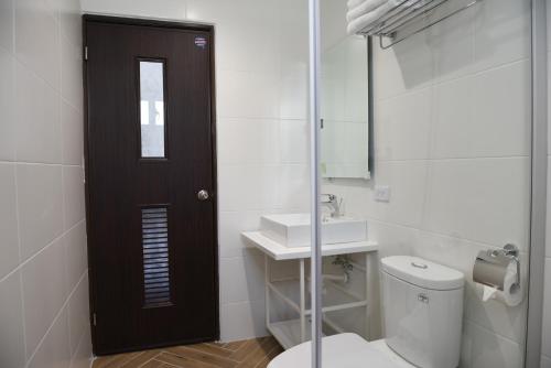 a bathroom with a toilet and a sink and a mirror at Ying Yue Homestay 台東縣登記民宿2029號 in Taitung City