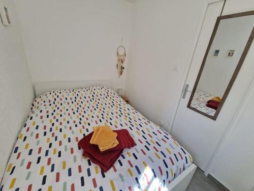 a small bedroom with a bed with a colorful comforter at Rez-de-jardin sous pins et plage in Saint-Mandrier-sur-Mer