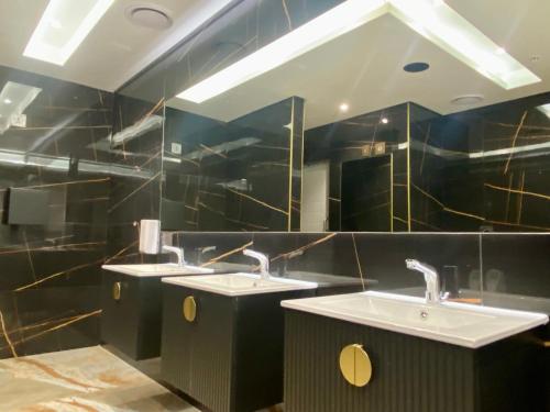 a bathroom with two sinks and two mirrors at Coastlands Skye Hotel, Ridgeside, Umhlanga in Durban