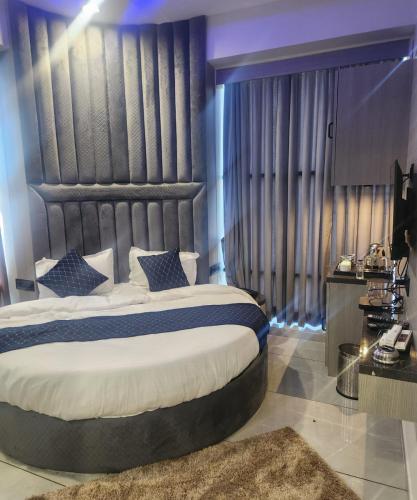 a bedroom with a large bed and a large window at Hotel Lee Pride in Anand