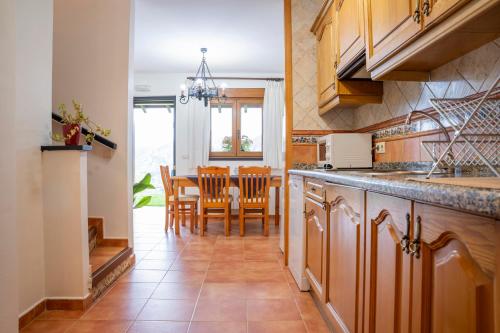 Una cocina y un comedor con mesa y sillas. en Apartamentos de turismo rural Buena Vista, en Cangas de Onís