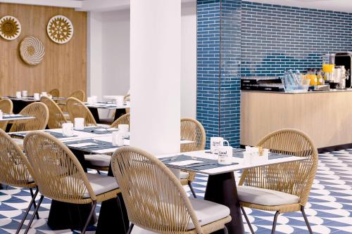 a dining room with tables and chairs and a counter at Exe Portals Nous in Portals Nous