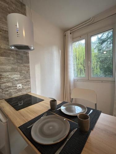 a kitchen with a table with plates on it at Ourasi - Hippodrome de Vincennes - Netflix in Saint-Maurice