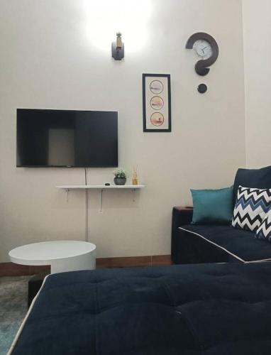 a living room with a couch and a table and a tv at Riverside Apartments in Buwate