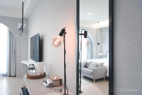 a living room with a floor lamp and a mirror at Ying Yue Homestay 台東縣登記民宿2029號 in Taitung City