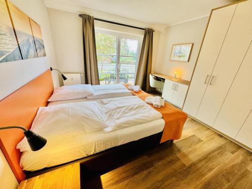 Un dormitorio con una cama grande y una ventana en Landhaus Immenbarg, Wellness, en Warnemünde