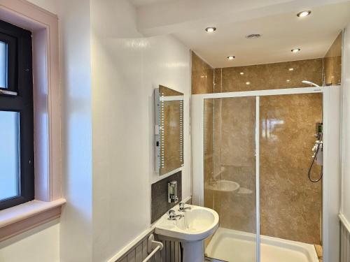 W łazience znajduje się umywalka i prysznic. w obiekcie Brae Lea House, Lochboisdale, South Uist. Outer Hebrides w mieście Lochboisdale
