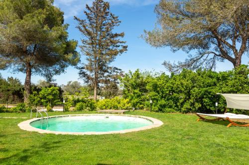 una piscina in erba con una sedia e un tavolo di Dèpendance - Lequile - Alfa Country House a Lequile