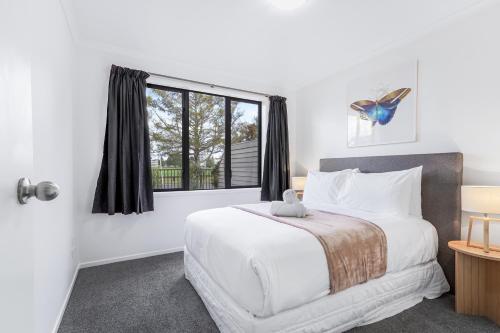 1 dormitorio con 1 cama blanca grande y ventana en Park Scenery, Proximity and Value - By KOSH BNB, en Hamilton