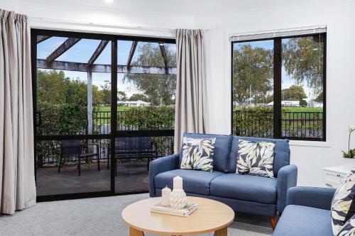 a living room with a blue couch and a table at Park Scenery, Proximity and Value - By KOSH BNB in Hamilton