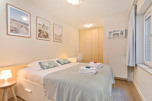 a bedroom with a bed with towels on it at Knokke La Douce - Cozy apartment with side sea-view at only 50 meters from beach in Knokke-Heist