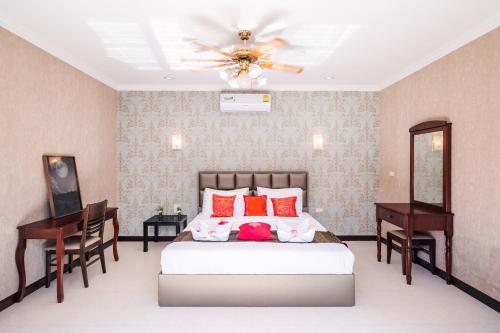 1 dormitorio con 1 cama y 2 escritorios en Coastal 3 BDR Private pool villa, en Pattaya South