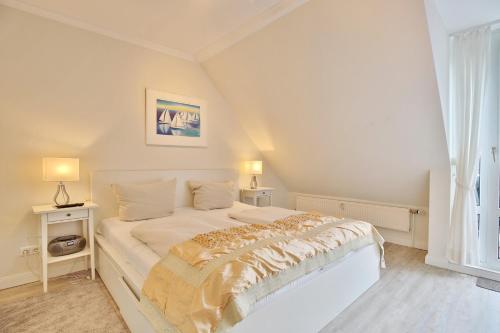 una camera da letto con un grande letto bianco con due lampade di Wohnpark am Mühlenteich Wohnpark am Mühlenteich Appartement 34 a Timmendorfer Strand