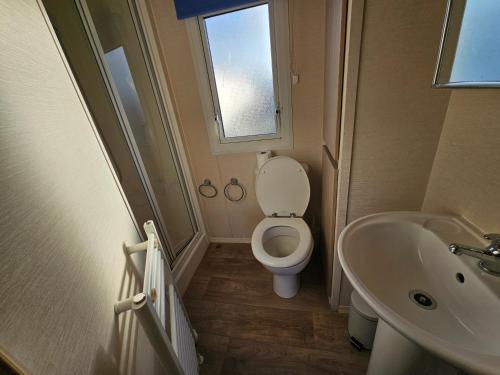 a small bathroom with a toilet and a sink at Caravan LEANNE in Meliden