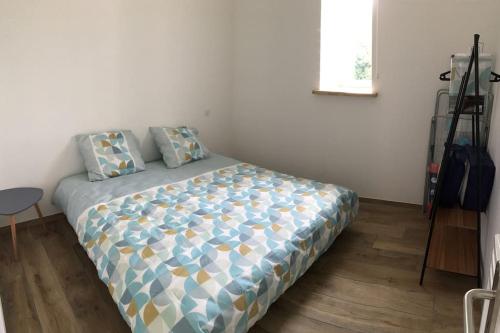 une chambre avec un lit dans une pièce dans l'établissement La p’tite Escale des Brias - L’escale des Brias, à Saint-Martin-Lacaussade