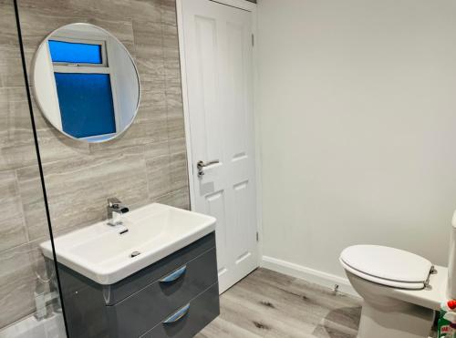 a bathroom with a sink and a mirror at K Suites - Drummond Close in Bracknell