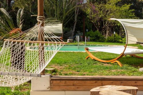 a hammock and a chair next to a pool at ALFA COUNTRY HOUSE Villa Salento in Lequile