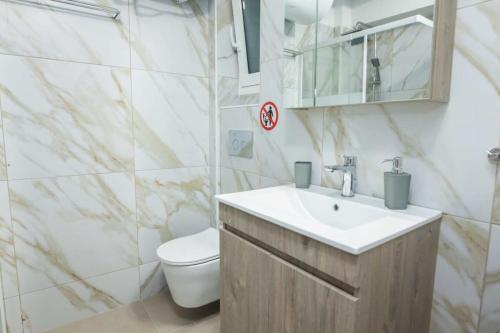 y baño con lavabo y aseo. en Charming Urban Oasis 1BR Apt near Megaro Mousikis, en Atenas