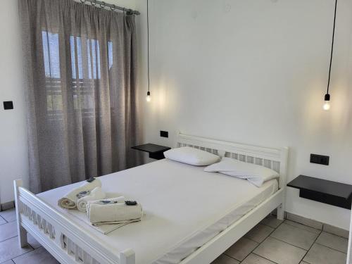 un letto bianco in una stanza con finestra di Aura Guesthouse a Kinira