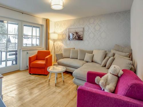 uma sala de estar com um sofá roxo e uma cadeira laranja em Holiday apartment in Feld am See in Carinthia em Feld am See