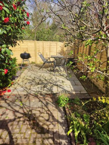 a patio with a table and chairs and a fence at Beautiful Bexhill Cottage with garden 3 mins walk to beach in Bexhill