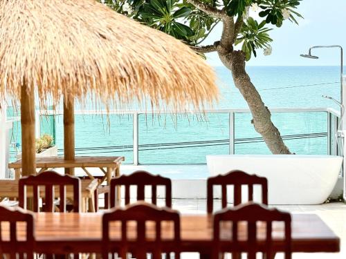 a table and chairs with a view of the ocean at Gao Bayview Banchang in Rayong