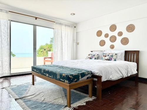 a bedroom with a bed and a large window at Gao Bayview Banchang in Rayong
