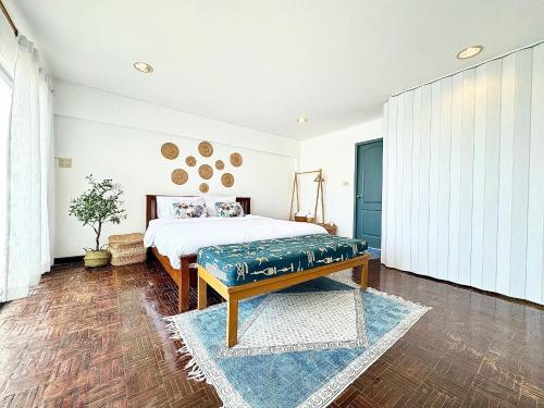 a bedroom with a bed with a bench in it at Gao Bayview Banchang in Rayong