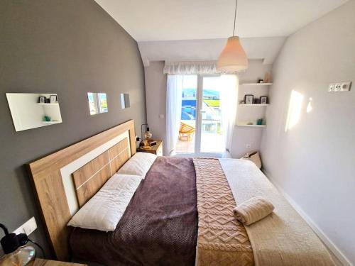 una camera con un grande letto e una finestra di Dúplex playa Foz. Vistas al Mar, Terraza y Piscina a Foz