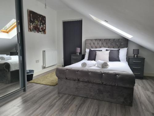 um quarto com uma cama grande e um espelho em SAV Apartments Leicester - 2 Bed Cosy Flat Saffron em Leicester