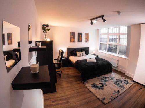 1 dormitorio con cama, escritorio y ventana en SAV Apartments Rutland Leicester, en Leicester