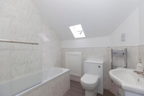 a bathroom with a tub and a toilet and a sink at SAV Apartments Clarence Street-Loughborough in Loughborough