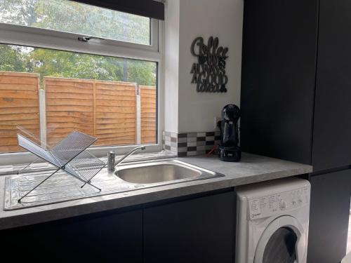 a kitchen counter with a sink and a window at SAV Apartments Leicester - 2 Bed Cosy Flat Saffron in Leicester