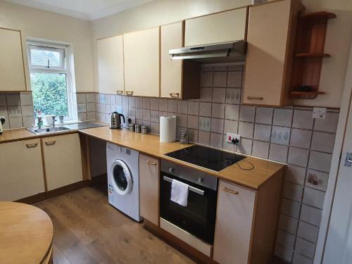 a kitchen with a stove and a dishwasher at SAV Apartments Watford in Watford