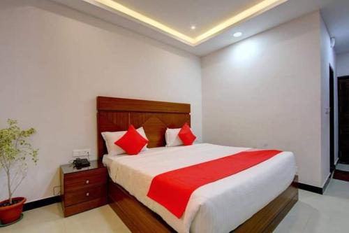 um quarto com uma cama grande e almofadas vermelhas em Hotel Le Castle em Kodaikanal