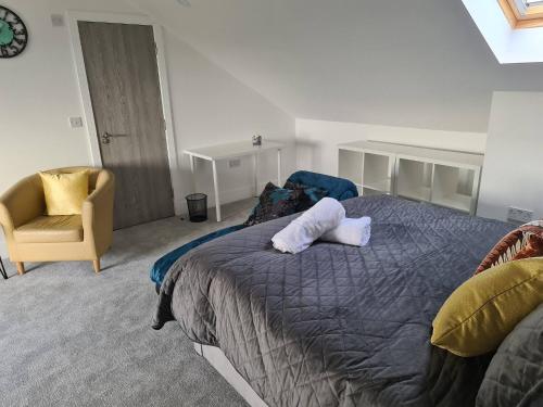 SAV 5 Bedroom Executive Detached House in Leicester في Humberstone: غرفة نوم بسرير كبير وكرسي