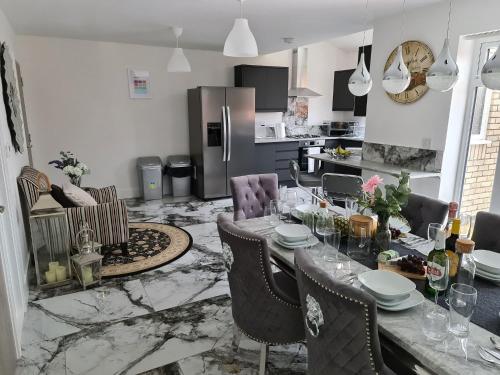 a kitchen and dining room with a table and chairs at SAV 5 Bed Luxury House Leicestershire in Humberstone