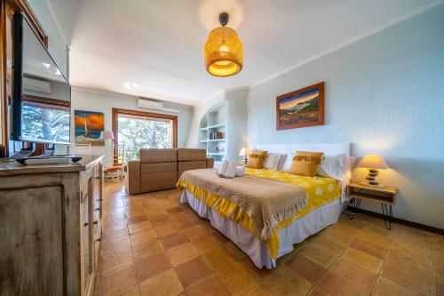 Villa Can Toni Lux Experience, ideal Familias con Vista Mar & AirCon في يوريت دي مار: غرفة نوم بها سرير وأريكة وتلفزيون