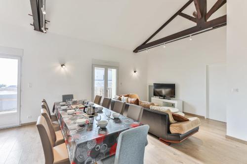 sala de estar con mesa y sofá en Côté Plage - Appartement 100m vue mer, en Saint-Jean-de-Monts