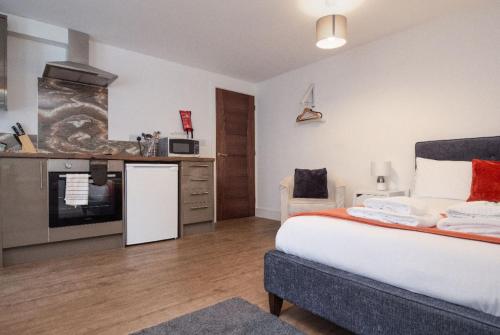 a bedroom with a large bed and a kitchen at SAV Apartments Regent Leicester in Leicester
